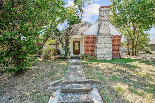 534 N Race St, Stephenville, TX 76401 - view of front of house with a chimney, brick siding, and a front lawn