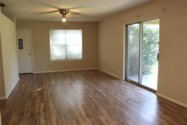 534 N Race St, Stephenville, TX 76401 - unfurnished living room featuring a ceiling fan, plenty of natural light, dark wood-type flooring, baseboards, and a textured ceiling