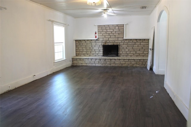 534 N Race St, Stephenville, TX 76401 - unfurnished living room featuring a ceiling fan, a brick fireplace, dark wood-type flooring, and baseboards