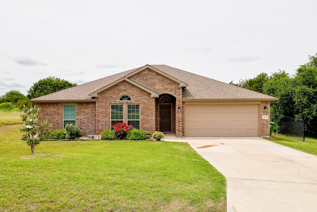 single story home with brick siding, a garage, a front yard, and concrete driveway