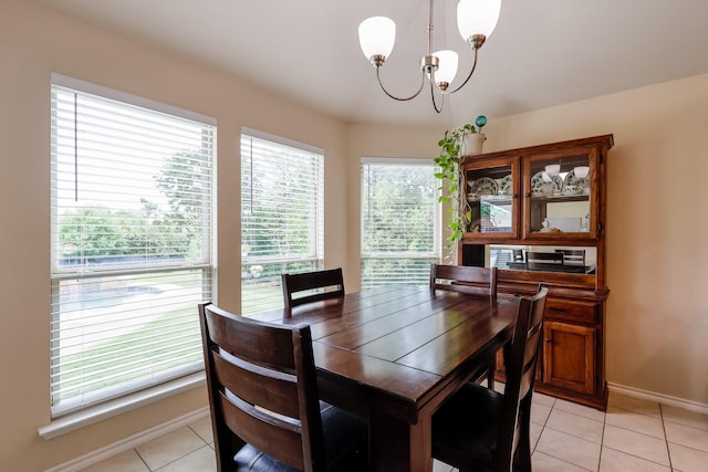 dining area with a chandelier, light tile patterned floors, and baseboards