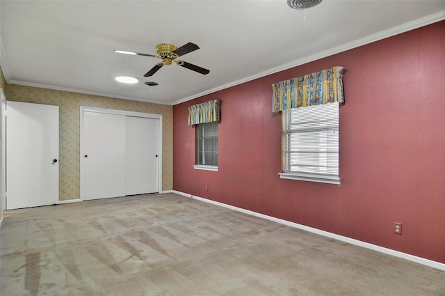 unfurnished bedroom with ornamental molding, carpet floors, baseboards, and ceiling fan