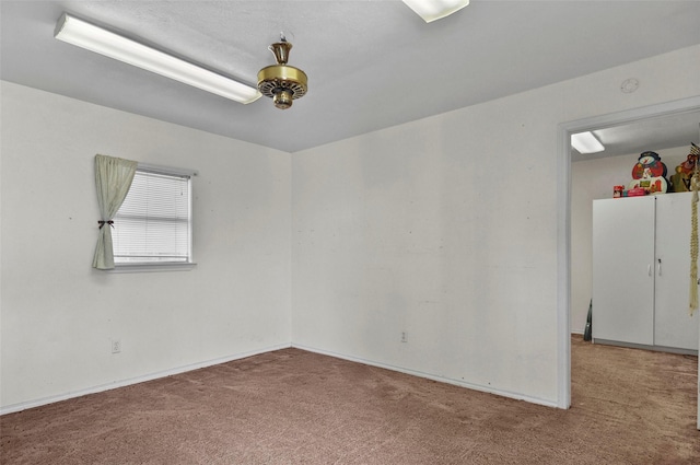 spare room featuring carpet floors and baseboards
