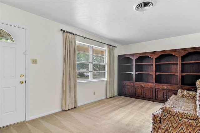 living area with light colored carpet and baseboards