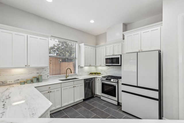 2576 Fountain Cv, Carrollton, TX 75006 - kitchen with appliances with stainless steel finishes, a sink, white cabinetry, dark tile patterned floors, and backsplash