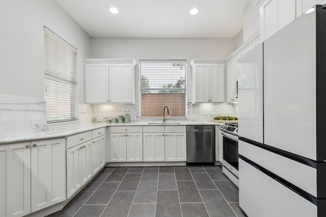 2576 Fountain Cv, Carrollton, TX 75006 - kitchen with dishwasher, white fridge, range with electric stovetop, a sink, and backsplash