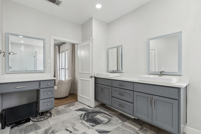 2576 Fountain Cv, Carrollton, TX 75006 - bathroom with a tile shower, double vanity, recessed lighting, and baseboards