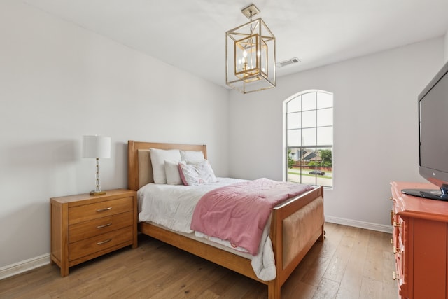 2576 Fountain Cv, Carrollton, TX 75006 - bedroom with a chandelier, light wood-style floors, and baseboards