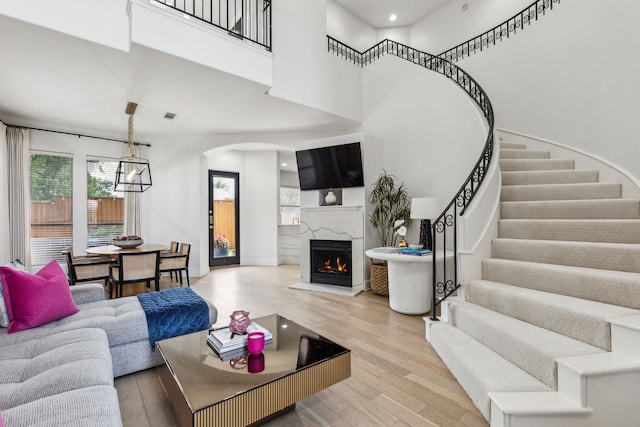 2576 Fountain Cv, Carrollton, TX 75006 - living room featuring arched walkways, wood finished floors, stairway, healthy amount of natural light, and a towering ceiling