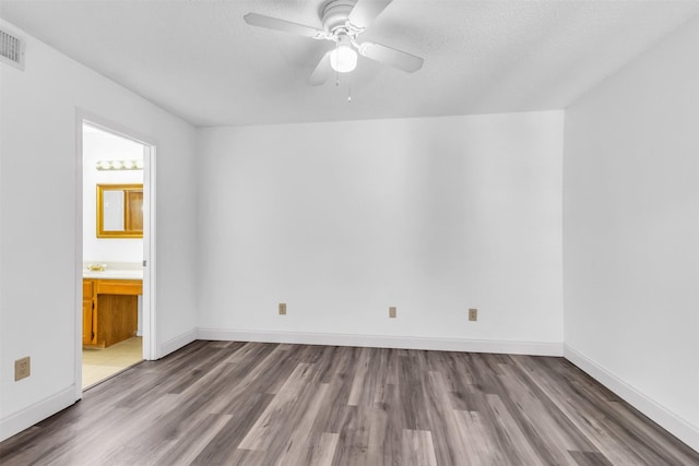 4242 N Capistrano Dr Unit 161, Dallas, TX 75287 - unfurnished bedroom featuring wood finished floors, baseboards, ensuite bath, ceiling fan, and a textured ceiling