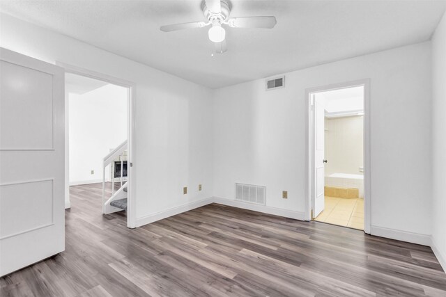 4242 N Capistrano Dr Unit 161, Dallas, TX 75287 - spare room with wood finished floors, a ceiling fan, stairs, and baseboards