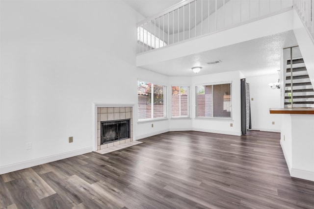 4242 N Capistrano Dr Unit 161, Dallas, TX 75287 - unfurnished living room with a tile fireplace, wood finished floors, baseboards, a high ceiling, and a chandelier