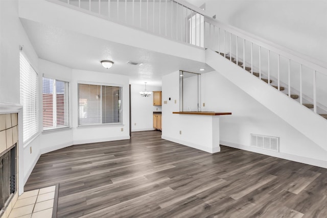 4242 N Capistrano Dr Unit 161, Dallas, TX 75287 - unfurnished living room with wood finished floors, stairway, a fireplace, and a chandelier