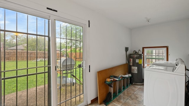 529 Proctor Ave, Waco, TX 76708 - laundry area featuring electric water heater, washing machine and clothes dryer, and light stone finish flooring