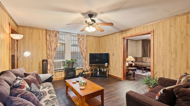 529 Proctor Ave, Waco, TX 76708 - living area featuring ceiling fan, a wood stove, wooden walls, a textured ceiling, and ornamental molding