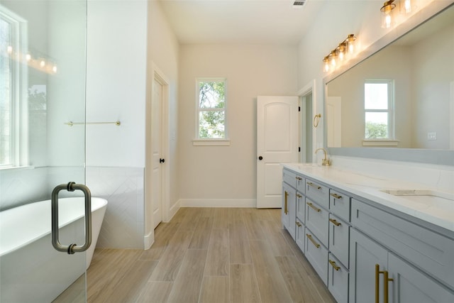 316 Falcon Ct, Springtown, TX 76082 - full bath with double vanity, a soaking tub, wood finished floors, and baseboards