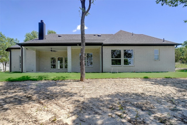316 Falcon Ct, Springtown, TX 76082 - back of property featuring ceiling fan, a chimney, brick siding, a yard, and a shingled roof