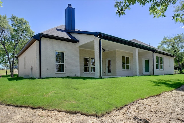 316 Falcon Ct, Springtown, TX 76082 - back of house with brick siding, a chimney, a yard, and ceiling fan