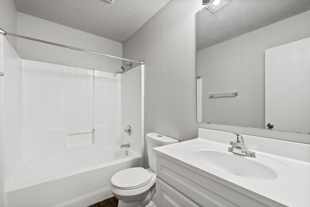 2118 W E Roberts Dr, Grand Prairie, TX 75051 - full bathroom with a textured ceiling, toilet, vanity, shower / bathtub combination, and wood finished floors