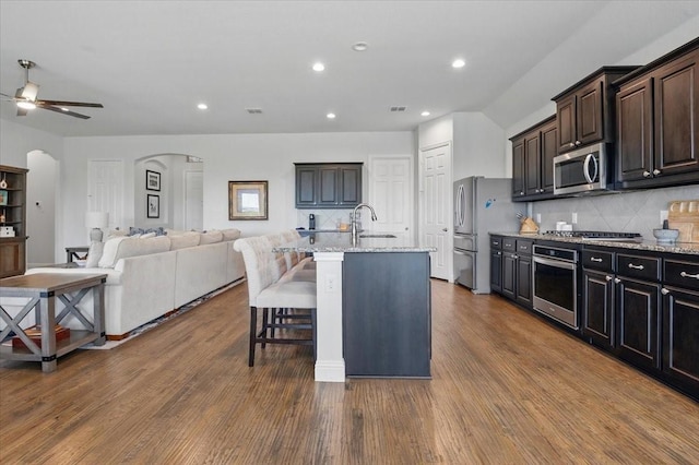 5009 Chisholm View Dr, Fort Worth, TX 76123 - kitchen featuring stainless steel appliances, arched walkways, decorative backsplash, open floor plan, and recessed lighting