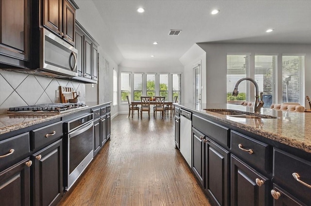 5009 Chisholm View Dr, Fort Worth, TX 76123 - kitchen with appliances with stainless steel finishes, a sink, dark wood finished floors, recessed lighting, and decorative backsplash