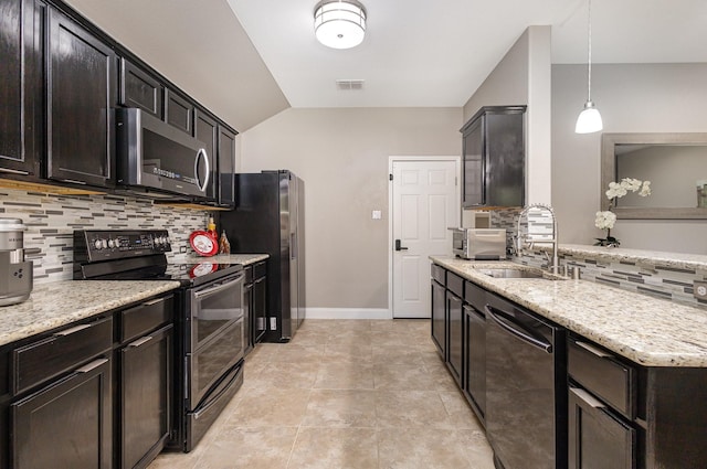 12604 Ocean Spray Dr, Frisco, TX 75036 - kitchen featuring appliances with stainless steel finishes, decorative backsplash, a sink, lofted ceiling, and light stone countertops