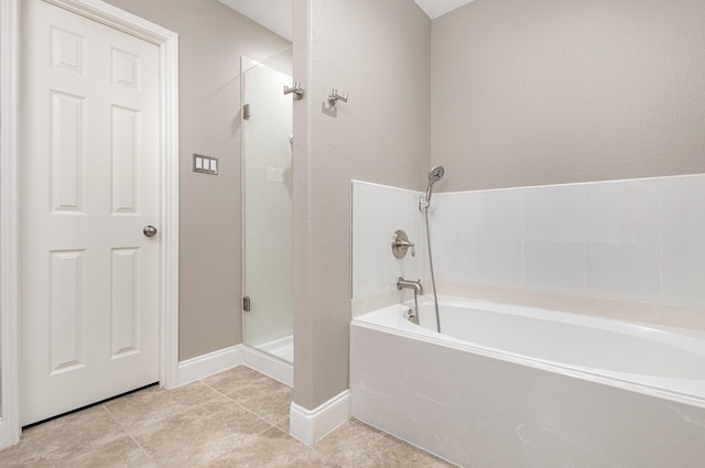 12604 Ocean Spray Dr, Frisco, TX 75036 - bathroom featuring a shower stall, a garden tub, tile patterned floors, and baseboards
