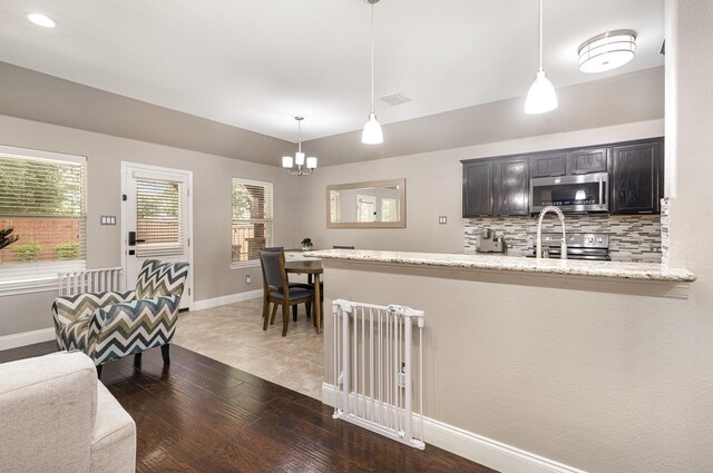 12604 Ocean Spray Dr, Frisco, TX 75036 - kitchen with stainless steel appliances, a chandelier, plenty of natural light, backsplash, and recessed lighting