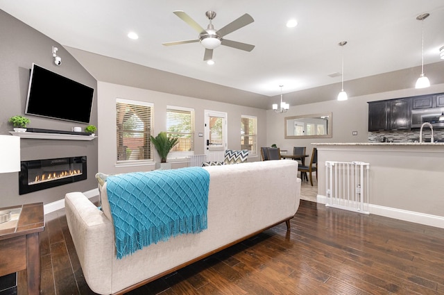12604 Ocean Spray Dr, Frisco, TX 75036 - living room with dark wood-style flooring, a glass covered fireplace, a ceiling fan, recessed lighting, and baseboards
