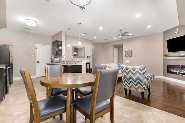 12604 Ocean Spray Dr, Frisco, TX 75036 - dining area with a ceiling fan, baseboards, recessed lighting, a glass covered fireplace, and light tile patterned floors