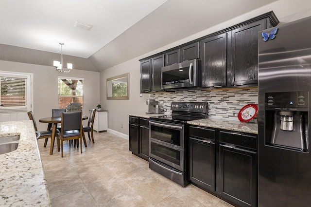 12604 Ocean Spray Dr, Frisco, TX 75036 - kitchen featuring appliances with stainless steel finishes, lofted ceiling, dark cabinetry, a chandelier, and backsplash
