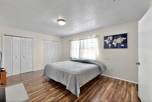 3714 Burning Tree Ln, Garland, TX 75042 - bedroom with two closets, wood finished floors, baseboards, and a textured ceiling