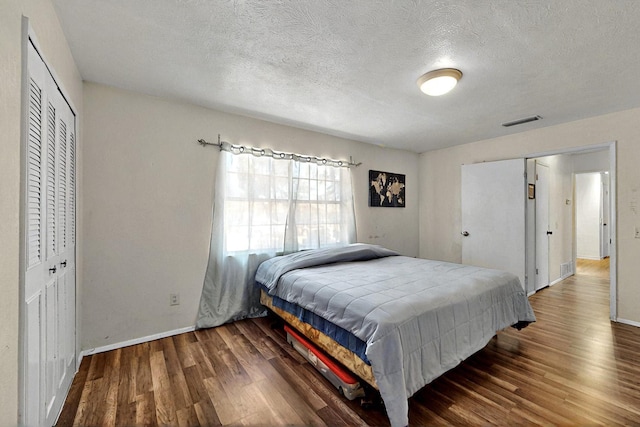 3714 Burning Tree Ln, Garland, TX 75042 - bedroom with wood finished floors, baseboards, a textured ceiling, and a closet