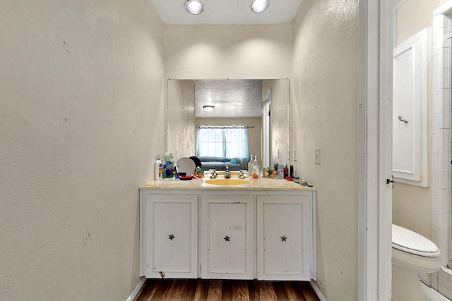 3714 Burning Tree Ln, Garland, TX 75042 - bathroom featuring wood finished floors, vanity, toilet, and baseboards