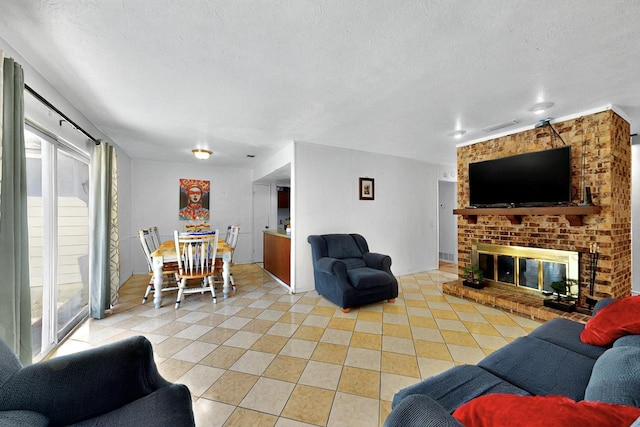 3714 Burning Tree Ln, Garland, TX 75042 - living room featuring light tile patterned flooring, a textured ceiling, and a brick fireplace