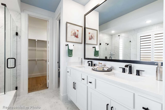 full bath with a shower stall, a spacious closet, double vanity, and recessed lighting