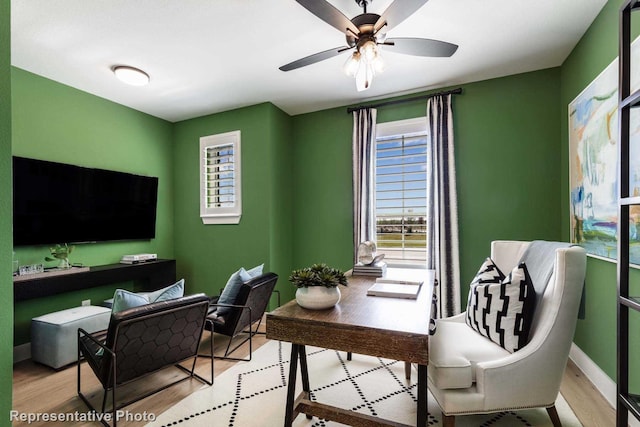 office space featuring baseboards, wood finished floors, and a ceiling fan