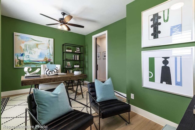 office area featuring baseboards, a ceiling fan, and wood finished floors
