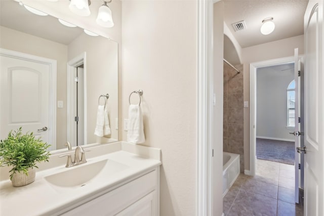 bathroom with tile patterned flooring, vanity, bathing tub / shower combination, and baseboards