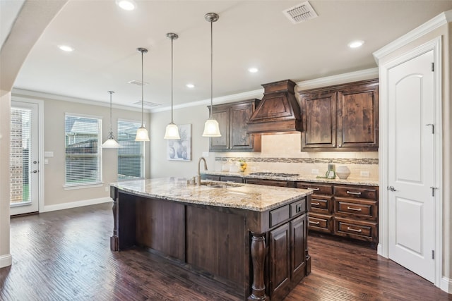 kitchen featuring custom range hood, tasteful backsplash, dark wood-type flooring, dark brown cabinetry, and light stone countertops