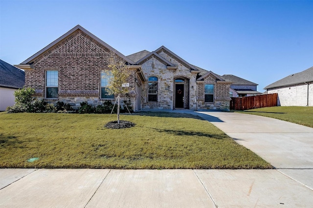 french country style house with brick siding and stone siding