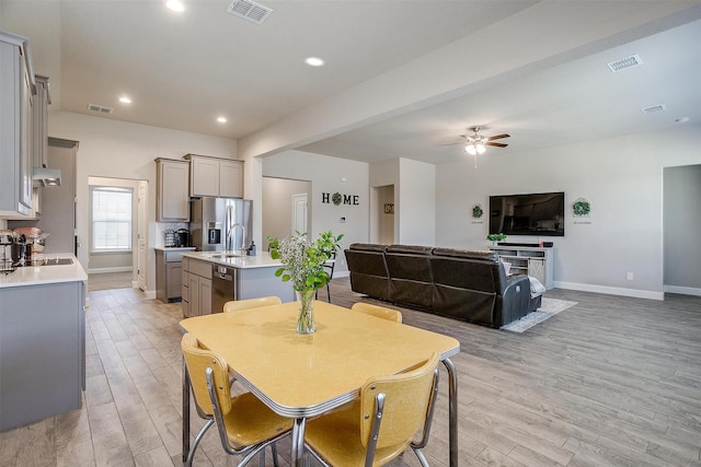 dining area with light wood-style flooring, a ceiling fan, baseboards, and recessed lighting