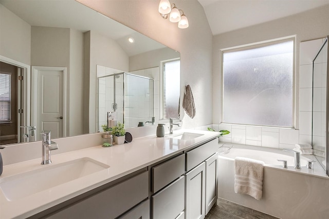 full bath with lofted ceiling, a shower stall, a bath, double vanity, and wood finished floors
