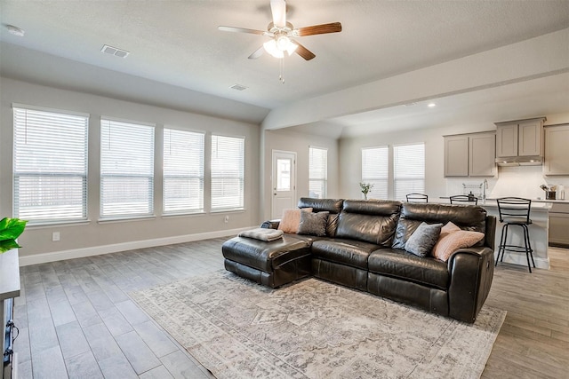 living area featuring a ceiling fan, light wood-style floors, baseboards, and recessed lighting