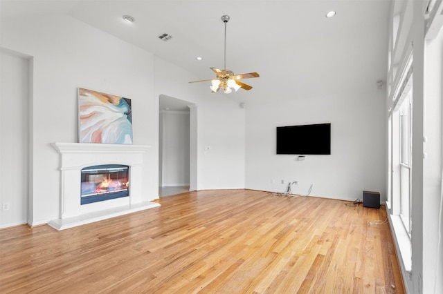2701 Royal Troon Dr, Plano, TX 75025 - unfurnished living room featuring ceiling fan, wood finished floors, a glass covered fireplace, high vaulted ceiling, and recessed lighting