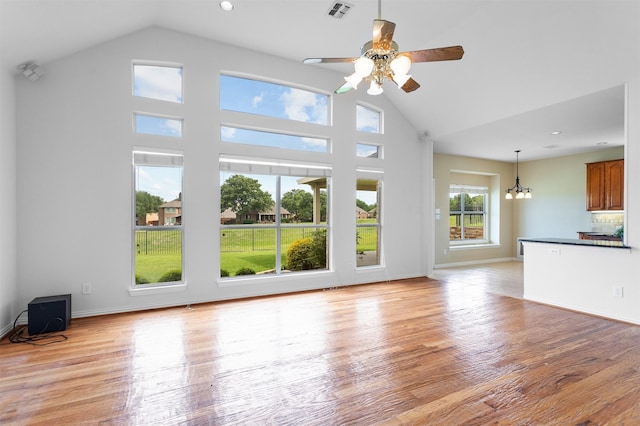 2701 Royal Troon Dr, Plano, TX 75025 - unfurnished living room with a ceiling fan, a chandelier, light wood-style floors, high vaulted ceiling, and baseboards