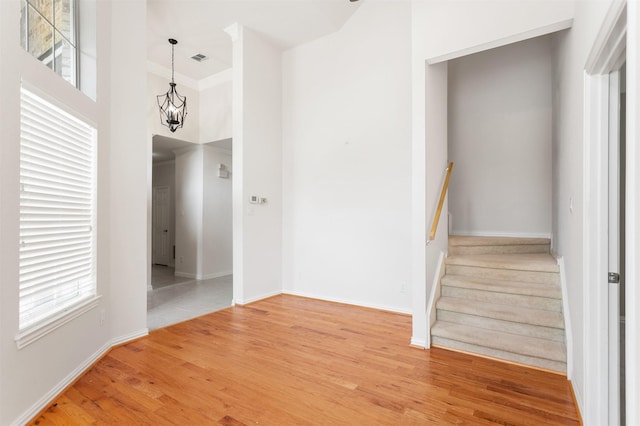 2701 Royal Troon Dr, Plano, TX 75025 - stairs with a chandelier, wood finished floors, a towering ceiling, baseboards, and crown molding