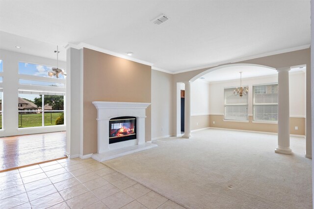 2701 Royal Troon Dr, Plano, TX 75025 - unfurnished living room with a chandelier, crown molding, a glass covered fireplace, light tile patterned floors, and decorative columns
