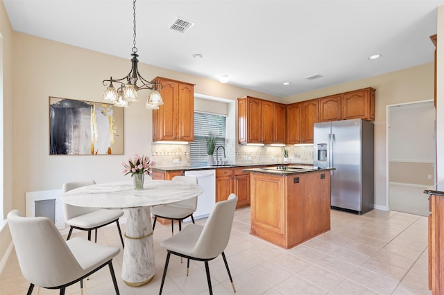 2701 Royal Troon Dr, Plano, TX 75025 - kitchen featuring stainless steel fridge, dishwasher, tasteful backsplash, a center island, and dark countertops