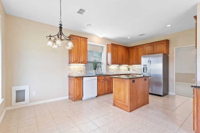 2701 Royal Troon Dr, Plano, TX 75025 - kitchen with stainless steel fridge, white dishwasher, backsplash, a chandelier, and a kitchen island